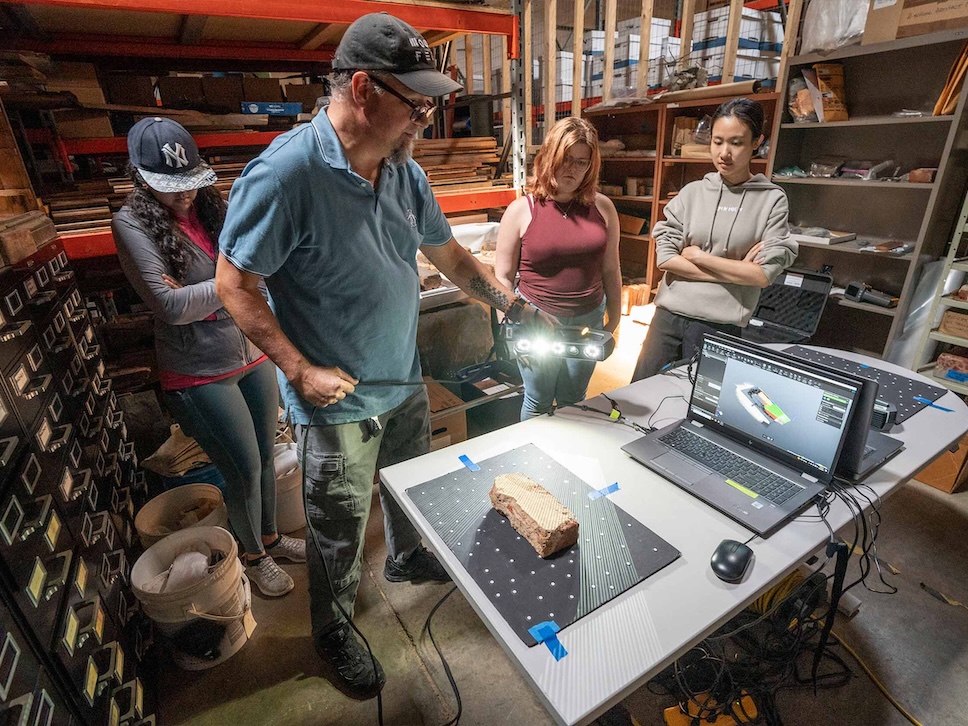 Decorative photo of Scholars' Lab staff and students scanning a cultural heritage artifact