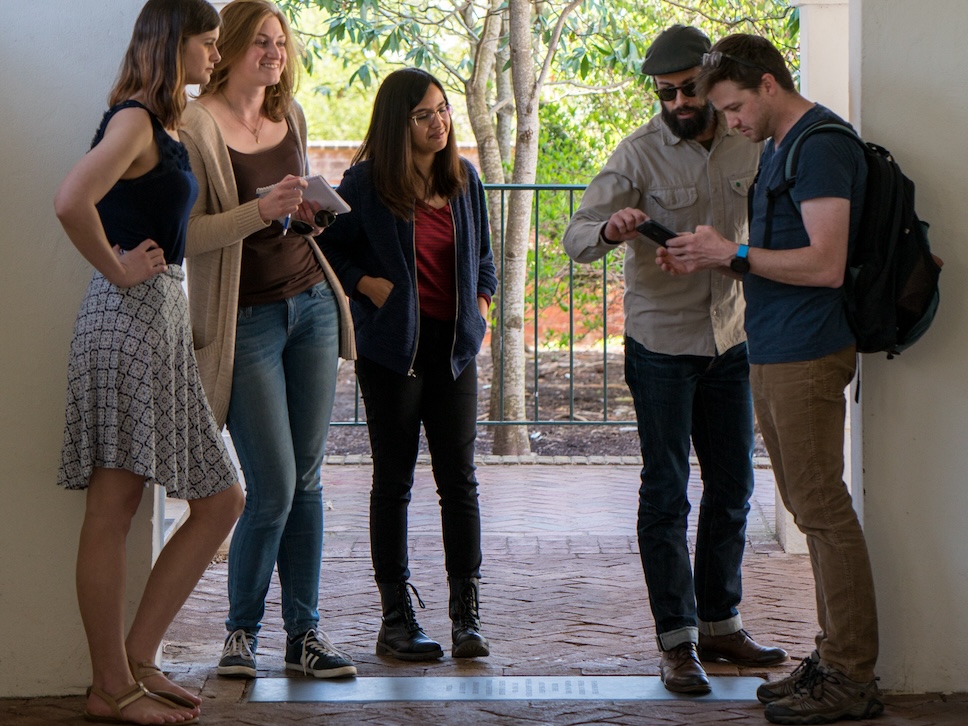 Decorative photo of Scholars' Lab fellows working with staff outdoors on a location-based augmented reality research project