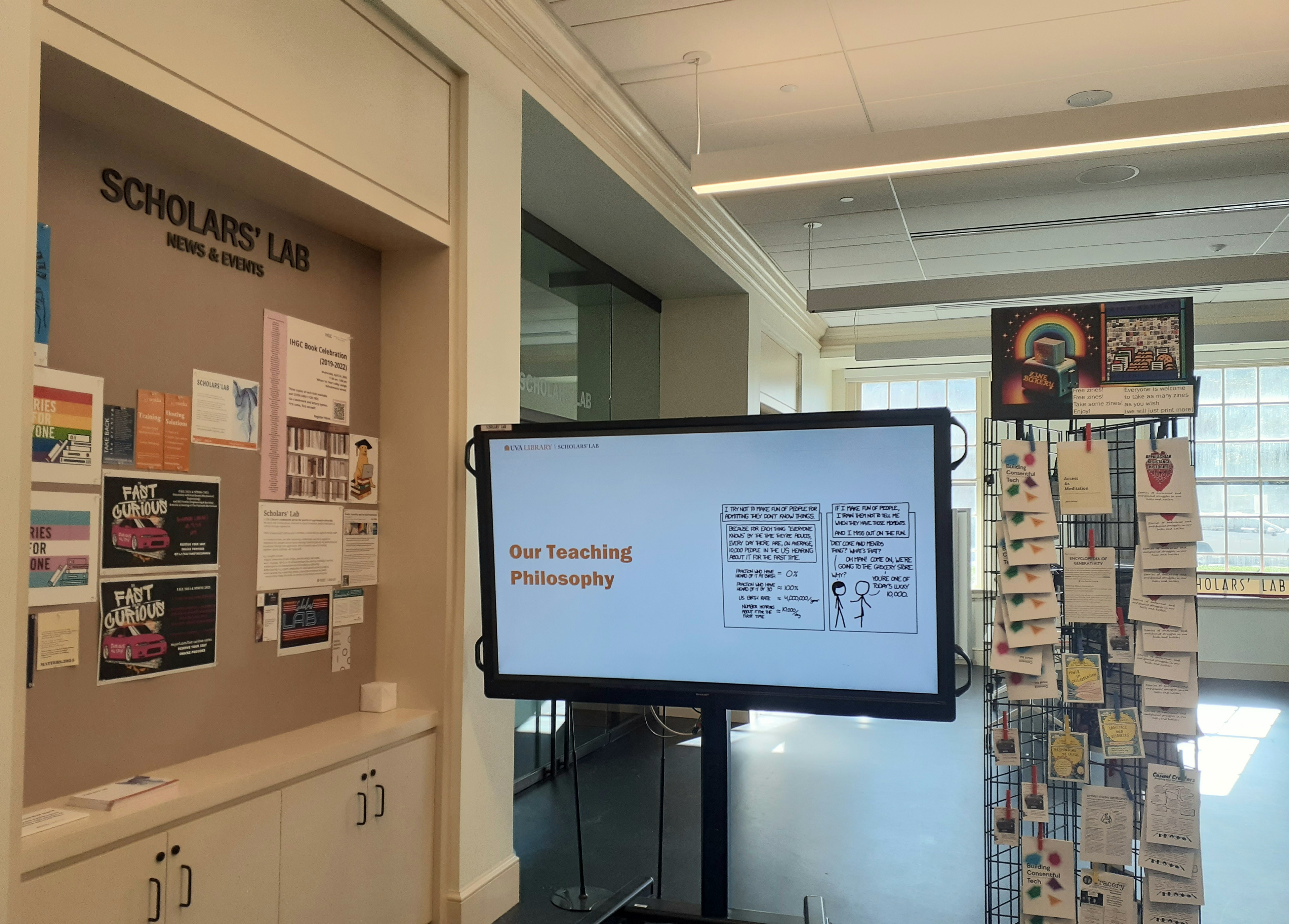 photo of the main scholars' lab entrance with zines, an introductory slide show, and a bulletin board