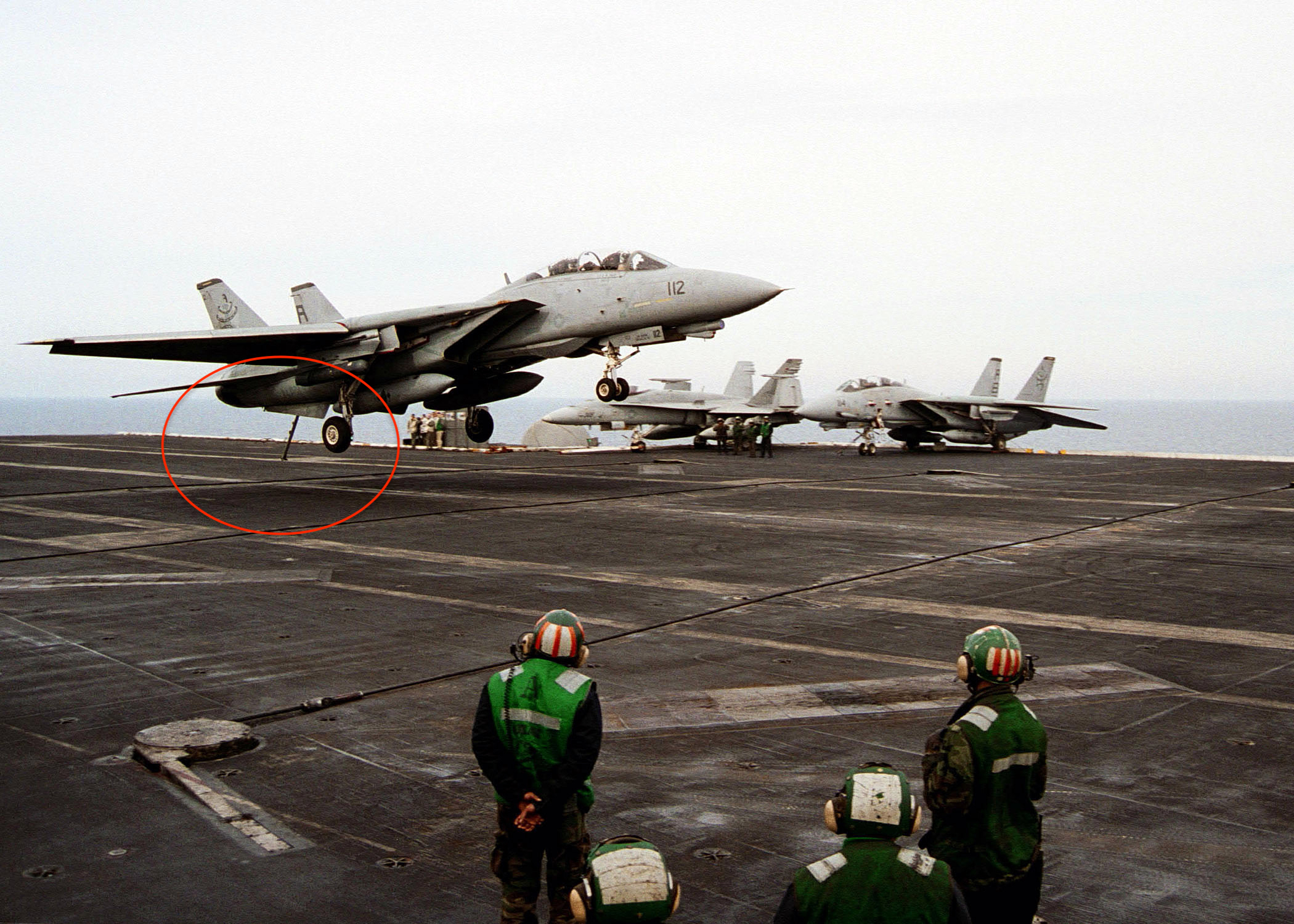 An F-14 Tomcat jet fighter assigned to the "Diamondbacks" of Fighter Squadron One Zero Two (VF-102) descends to make an arresting gear landing on the flight deck.